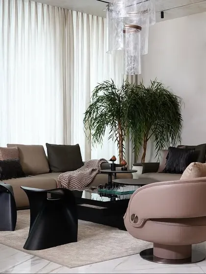 This angle highlights the seating arrangement in the living room, with a mix of a large sectional sofa and stylish accent chairs. The design focuses on creating multiple conversation zones within a single, open space.