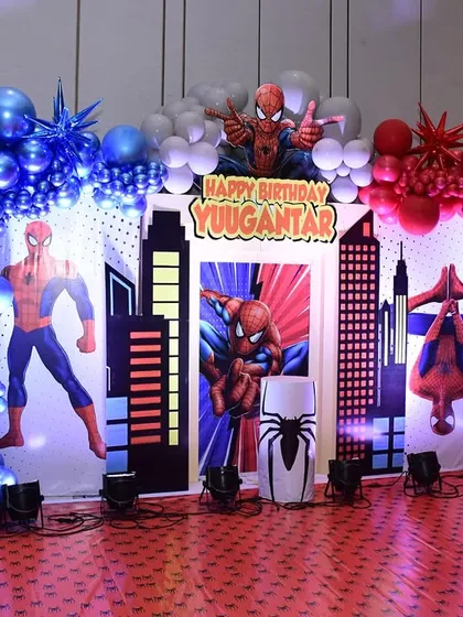 An amazing Spider-Man themed backdrop for a 4th birthday, complete with cityscapes and balloon arches in classic red and blue.