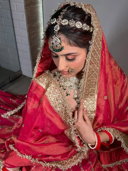 A bride in a red silk lehenga with a contrasting dupatta. This look is perfect for a traditional ceremony, combining classic colors with rich fabrics.
