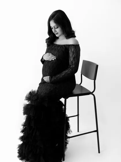 A timeless black and white portrait of a mom-to-be in our black lace off-the-shoulder gown.