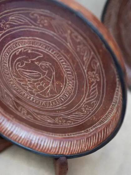 Inspired by antique bronze plates, these intricately carved ceramic plates were crafted by a student in our Foundation course. The detailed sgraffito work and rich glaze give them a timeless, heirloom quality.