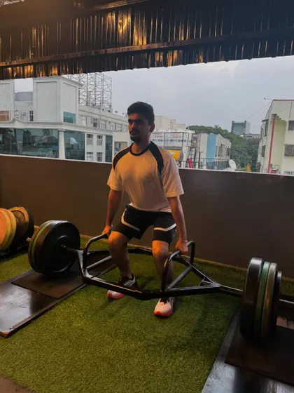A client lifts a heavily loaded trap bar. This variation of the deadlift is often easier on the lower back and is a great tool for building overall strength.