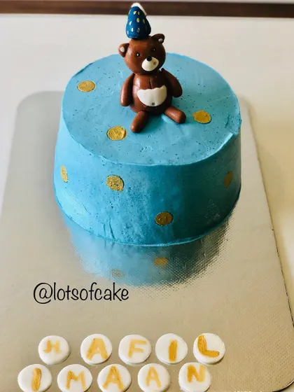 This cute teddy bear cake is an eggless chocolate cake with whipped cream frosting. I use minimal fondant accents, like the bear and the personalized name discs, to keep the focus on the delicious cake itself.