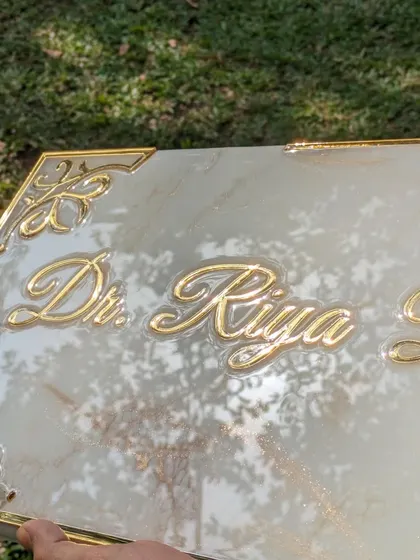 A detailed look at the golden acrylic lettering and corner embellishments on the marble-themed nameplate I created for a doctor's office. The precision of the laser-cut acrylic provides a sharp, professional look.