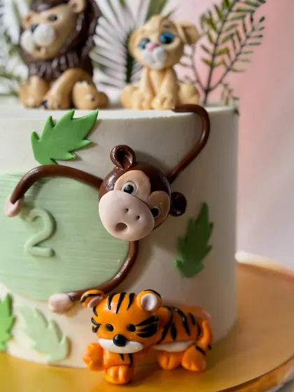 Here's a closer look at the playful fondant monkey and tiger figures. These small details add personality and charm to the overall cake design.