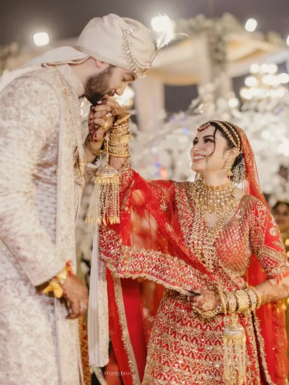 A gentle moment where the groom kisses his bride's hand during their wedding ceremony.