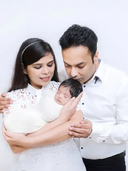 New parents gaze lovingly at their sleeping newborn. This photo captures the quiet, tender moments right after a new baby arrives.