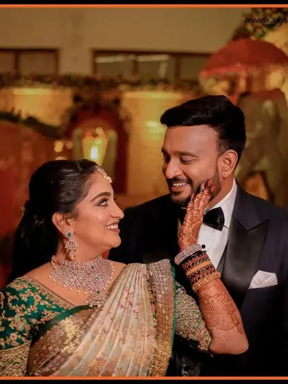 A tender moment between the couple at their reception. The bride's touch and their shared smile create a beautiful, candid photograph full of emotion.