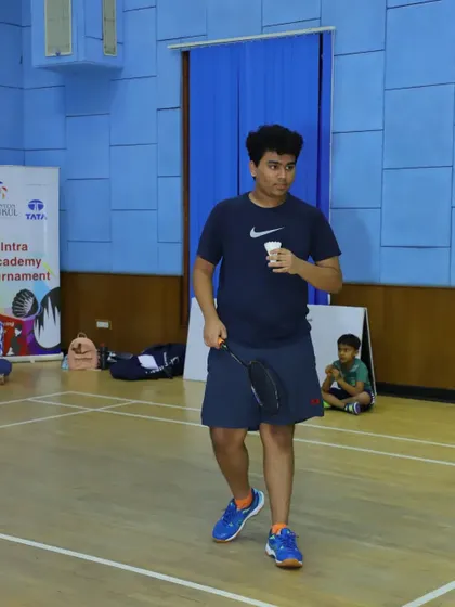 A player prepares to serve during a match, showcasing the calm and focus we teach for competitive situations.