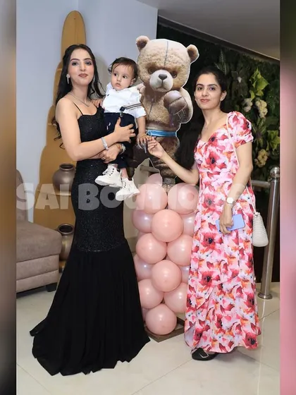 A happy family moment. My clients look stunning in their custom outfits, including a black sequin mermaid gown and a floral print dress, showcasing my versatile design skills.