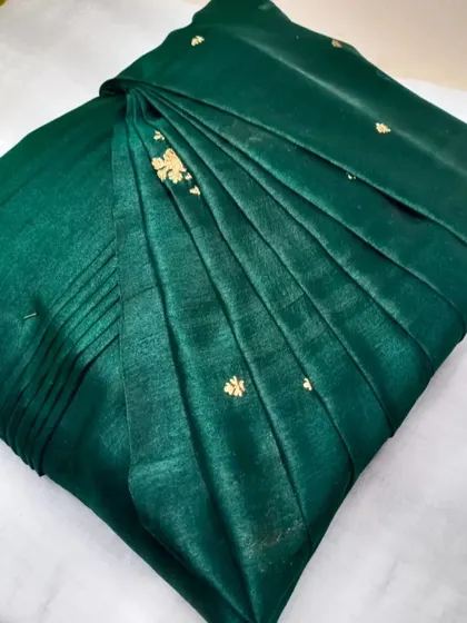 A deep green saree with delicate gold buttis. The pleats are done neatly, making it perfect for any occasion.