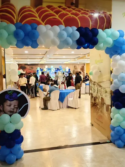 The entrance to the Krishna themed birthday, with a balloon arch and a personalized photo stand.