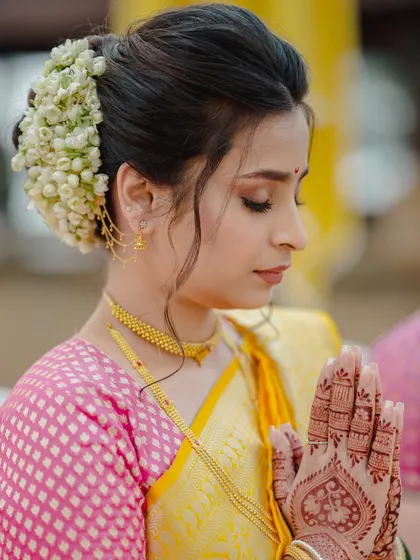 A moment of prayer. This close-up shows the intricate henna design and the beautiful, clean makeup look with a traditional bun.