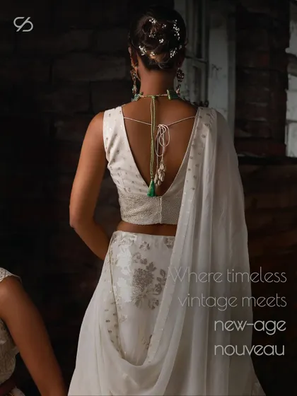 Where timeless vintage meets new-age nouveau. The back of this white lehenga showcases a deep cut and delicate tie-ups, blending classic elegance with modern design.