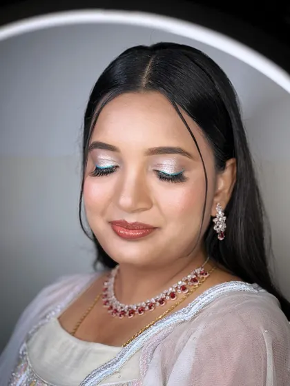 A close-up of Dhanyatha's reception makeup. We added a playful pop of teal liner under the eye to complement the shimmery lids and her white outfit, creating a unique and modern look.