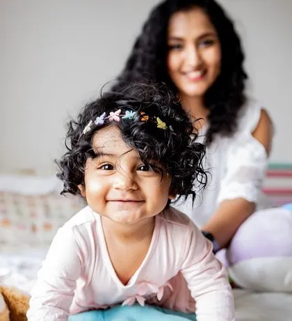 A playful toddler crawling towards the camera with a cheeky grin. Black and white photography brings out so much personality and character.