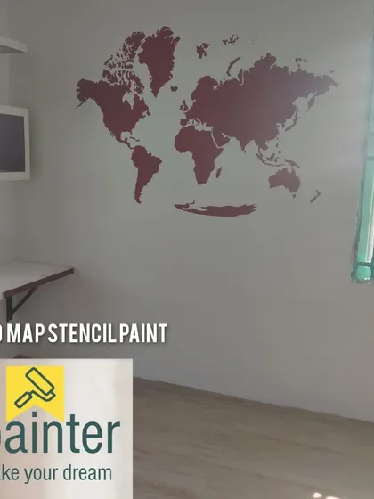 A world map stencil painted in red on a white wall. This is a popular design for a study, office, or kids' room, inspiring travel and learning.