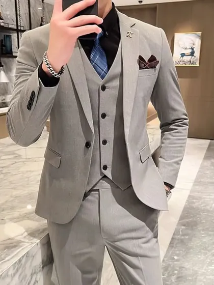 A classic light grey three-piece suit, a versatile staple for any wardrobe. This client is ready for a formal event or an important business meeting.