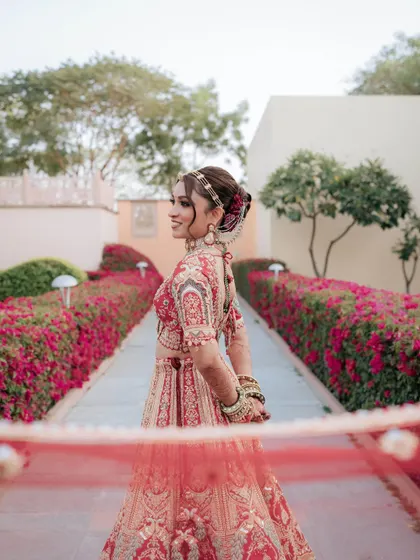 The bride looks serene and beautiful in this outdoor shot. Her makeup is fresh and radiant, perfect for a daytime wedding ceremony.