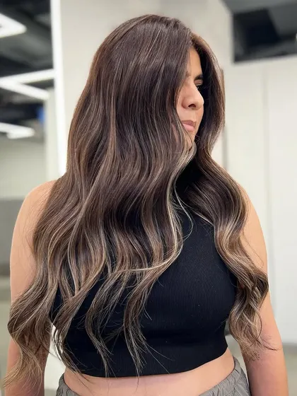 A side view of a signature balayage, highlighting the seamless blend of colors and the flattering, face-framing pieces.