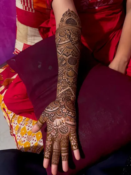 A single arm view of a bridal design with the name 'Khalil' written in beautiful Arabic script on the palm.