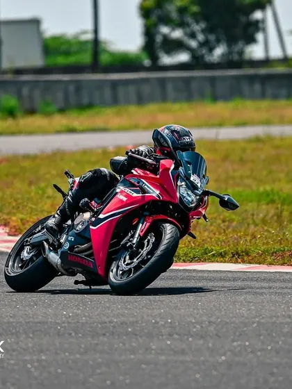 A rider on a red Honda CBR demonstrates smooth cornering technique during an open session at Madras International Circuit.