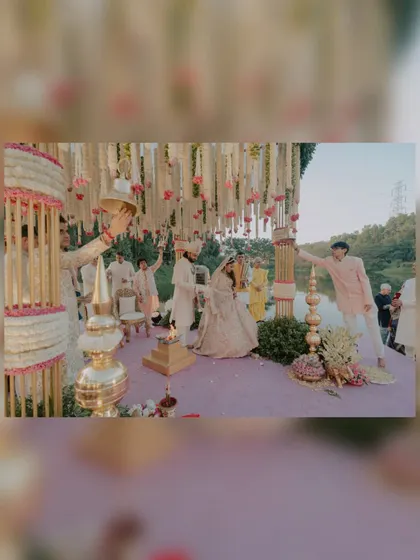 A wide shot of the Pheras ceremony by the lake, showing the beautiful mandap and the couple taking their sacred vows surrounded by loved ones.