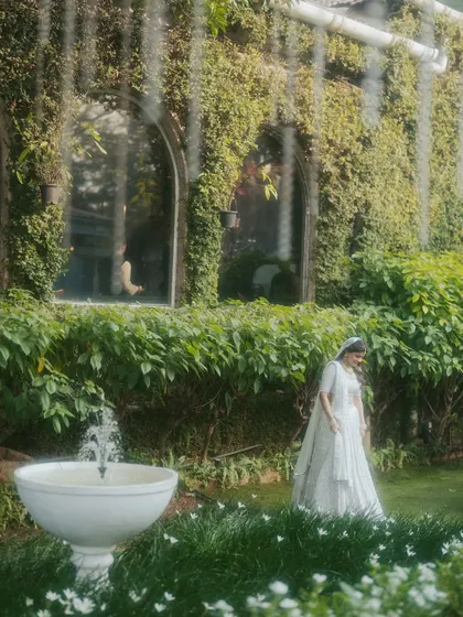 A serene bridal portrait in a lush garden. We use the natural environment and architectural elements to create beautiful, composed shots.