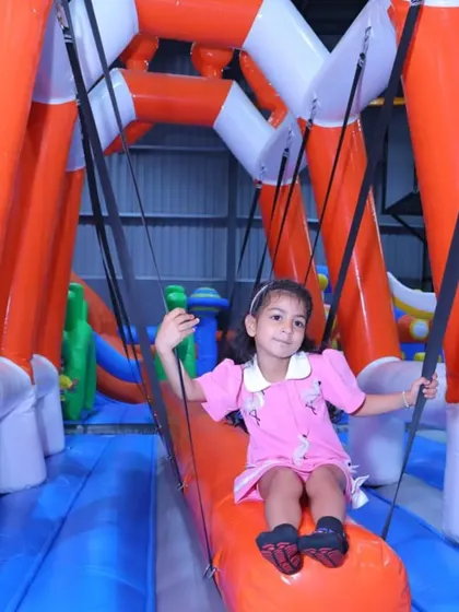A young princess enjoys a ride on the inflatable swing, a gentle and fun activity for all.