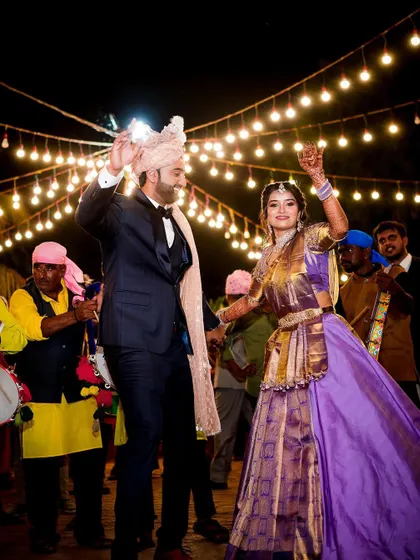 The bride and groom dancing their hearts out during the Baraat. We focus on capturing the movement and happiness of the celebration under the festive lights.
