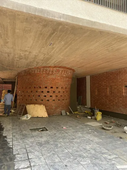 The "Waterfall" house under construction, with the curved brick wall of the "globule" taking shape in the parking area.