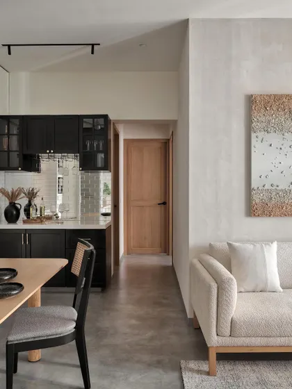 In the Zen House living room, a luxurious boucle sofa with arava texture invites you to lounge. The bespoke oak dining table stands as an open invitation to create cherished moments with loved ones.