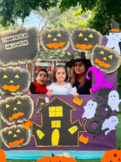 Three friends, one in a devil costume, pose with their mother at our Halloween event. Our workshops are a great way for children and parents to socialize and have fun.