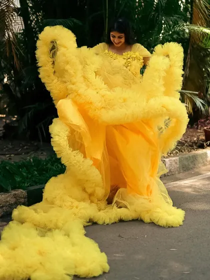 Playing with the layers of our yellow ruffle gown during a photoshoot.