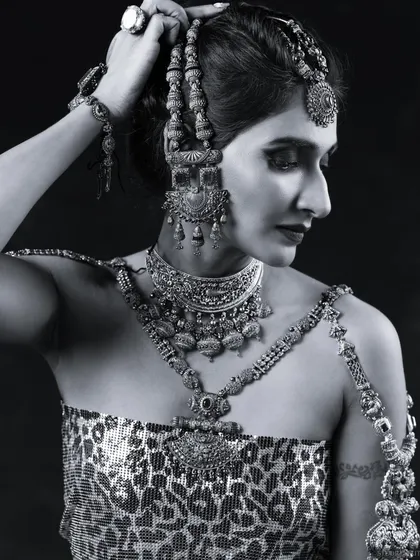 The same powerful look in black and white. This emphasizes the contrast and texture of the makeup and jewellery, showing how the look translates into monochrome for magazine editorials.