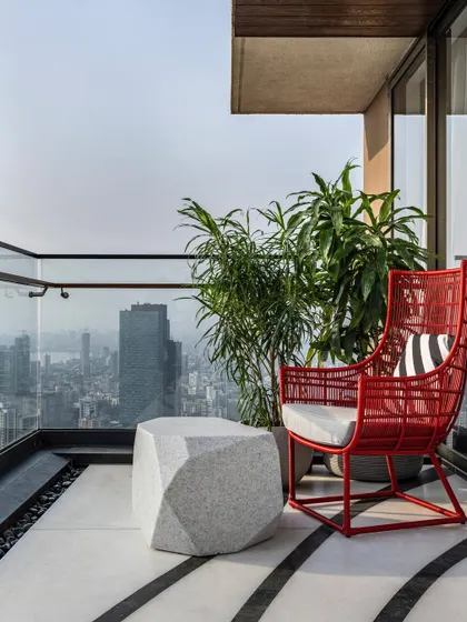 Perched on the 45th floor, this penthouse balcony offers an unrivalled 180-degree view of Mumbai’s skyline and coast. We designed this space to feel like you are on top of the world, with a plush red chair perfect for savoring a coffee as the city glitters below.