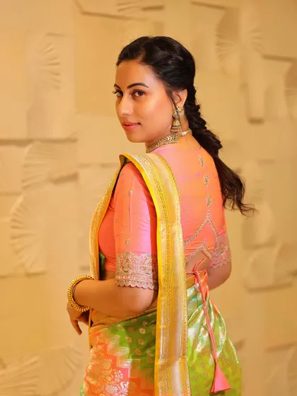 A back view of Dr. Shruthi, showing the beautiful embroidery on her blouse that complements the vibrant saree.