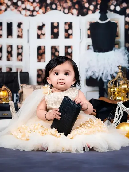 This little fashionista is checking her finances, holding a small black wallet in her chic photoshoot.