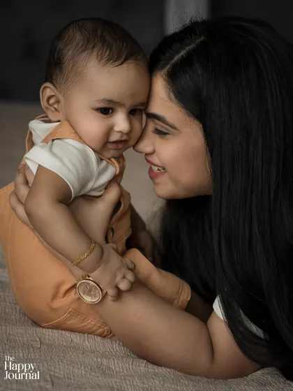 A tender moment between a mother and her sleeping baby. The soft lighting and close framing create an intimate and peaceful portrait.
