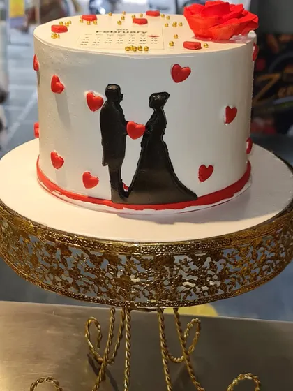 Celebrate your love story with this custom anniversary cake. It features a calendar marking the special day, romantic silhouettes, and a heart-themed design.