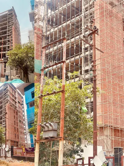 This collage from a site visit provides multiple angles of the building's concrete and brick structure. It documents the construction progress and the interplay of the building with its urban surroundings, including nearby trees and power lines.