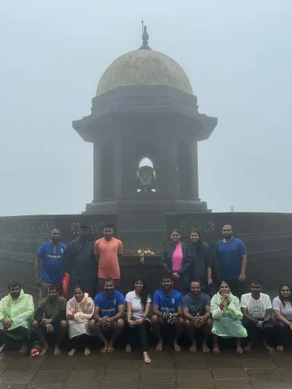 Group photo at a historic monument on a foggy day in Maharashtra. The mist adds a mysterious vibe to the place.