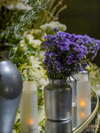 A beautiful arrangement of purple statice in a modern silver vase, showcasing the cool-toned floral palette used throughout the event to complement the blue and silver decor.