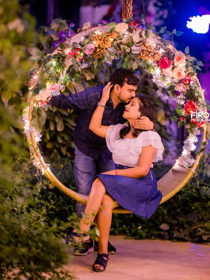A sweet, intimate moment on a decorated swing. The floral and light decorations create a magical and romantic atmosphere.