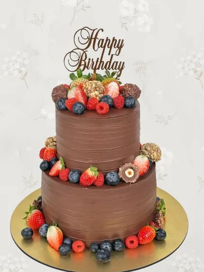 A two-tiered chocolate lover's dream. This birthday cake is covered in smooth chocolate frosting and decorated with fresh berries and Ferrero Rocher chocolates.