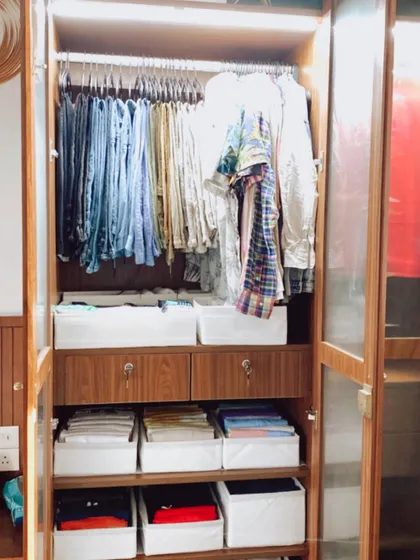 A perfectly organized men's wardrobe. We use a combination of hanging space and categorized bins to create a system that is both visually appealing and highly practical for daily use.