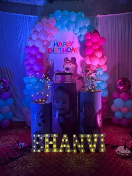 A Masha and the Bear themed birthday party. The decoration features custom-printed plinths with characters from the show and a blue and pink balloon arch.