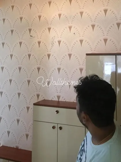 An art deco-inspired geometric fan pattern wallpaper being installed in a foyer, adding a touch of vintage glamour.