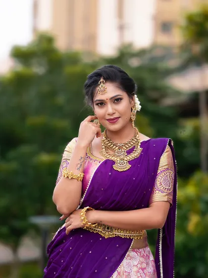 A model in a half-saree, styled with a heavy, antique-finish choker and haram set for a traditional photoshoot.