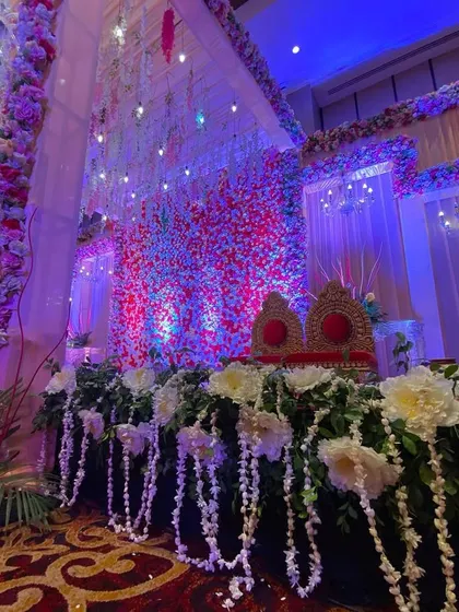 A side view of the indoor floral stage, highlighting the lush greenery and hanging flower details.